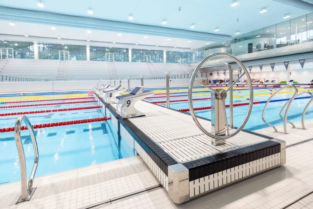 Myrtha movable bulkhead with handwheel spanning a competition pool